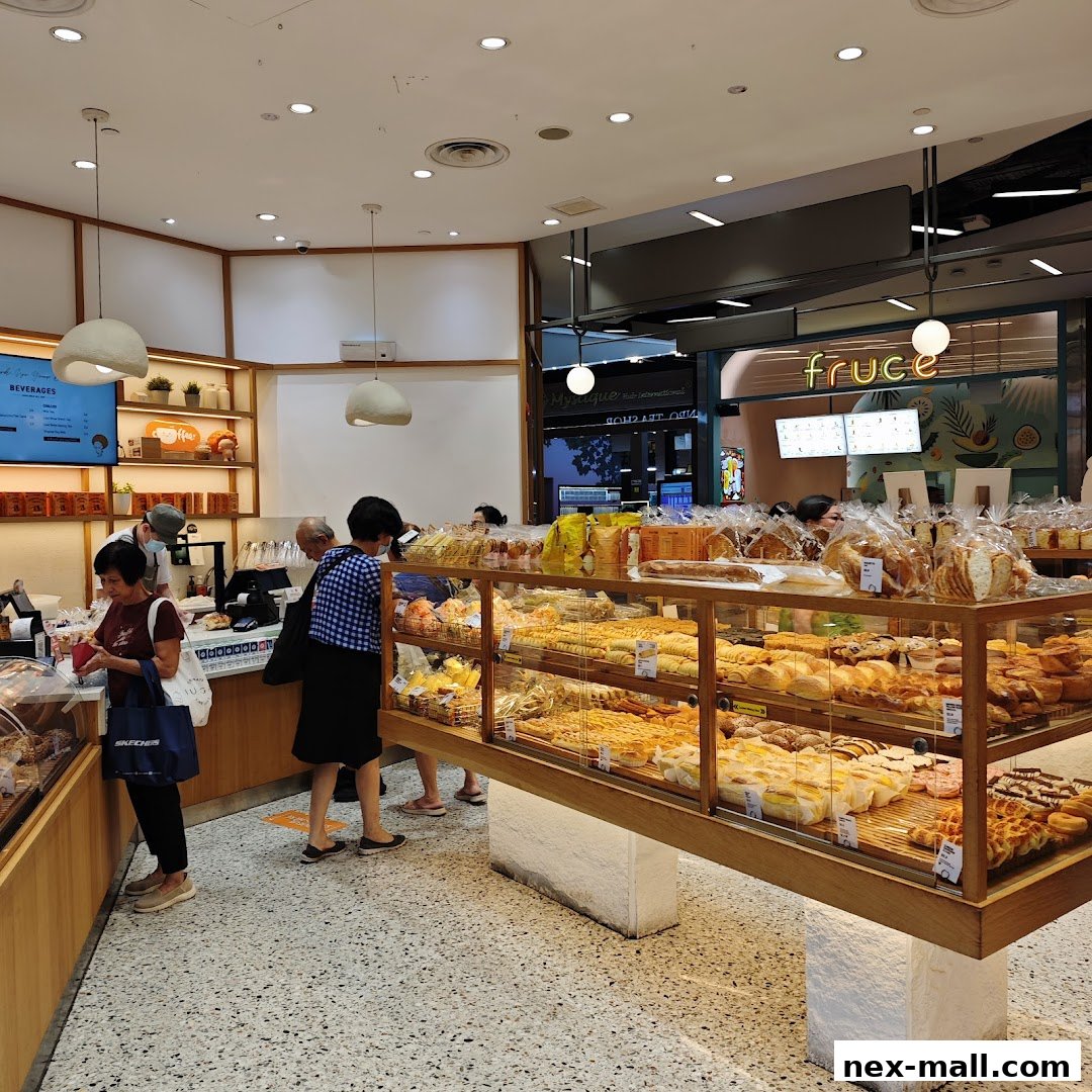 Customers browse a wide selection of fresh bread and pastries displayed in a modern bakery.
