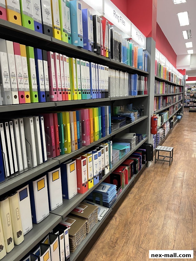 A wide aisle of shelves filled with colorful ring binders and office supplies.