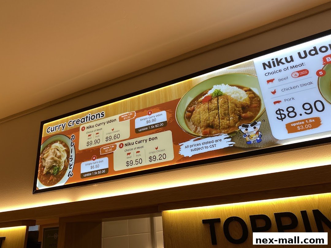 A brightly lit menu board showcasing various curry udon and curry don dishes with prices.