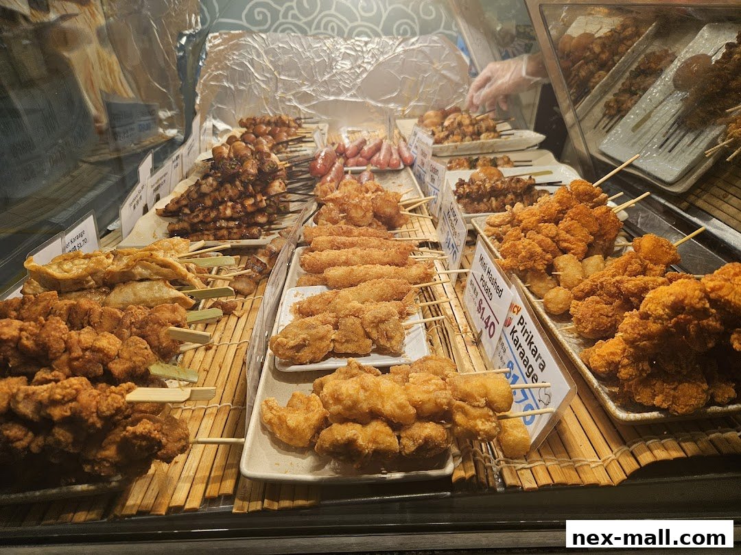 A display of various Japanese skewers and fried snacks, including chicken karaage and gyoza.