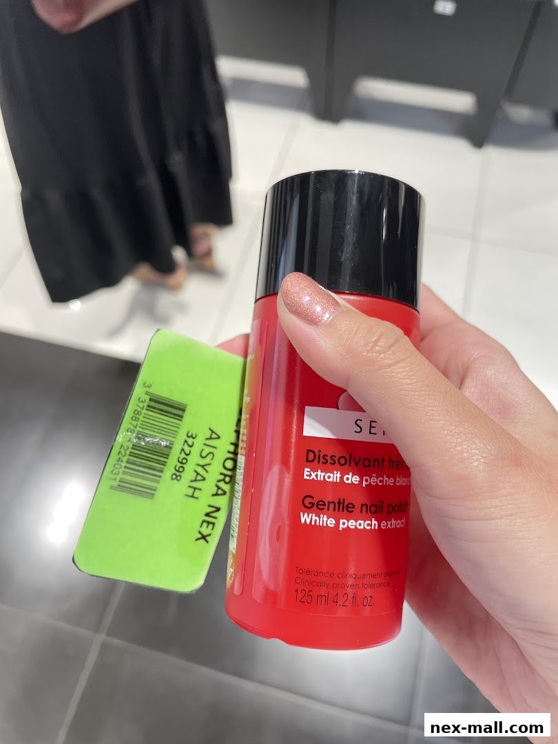 A hand holds a bottle of Sephora nail polish with a price tag attached.