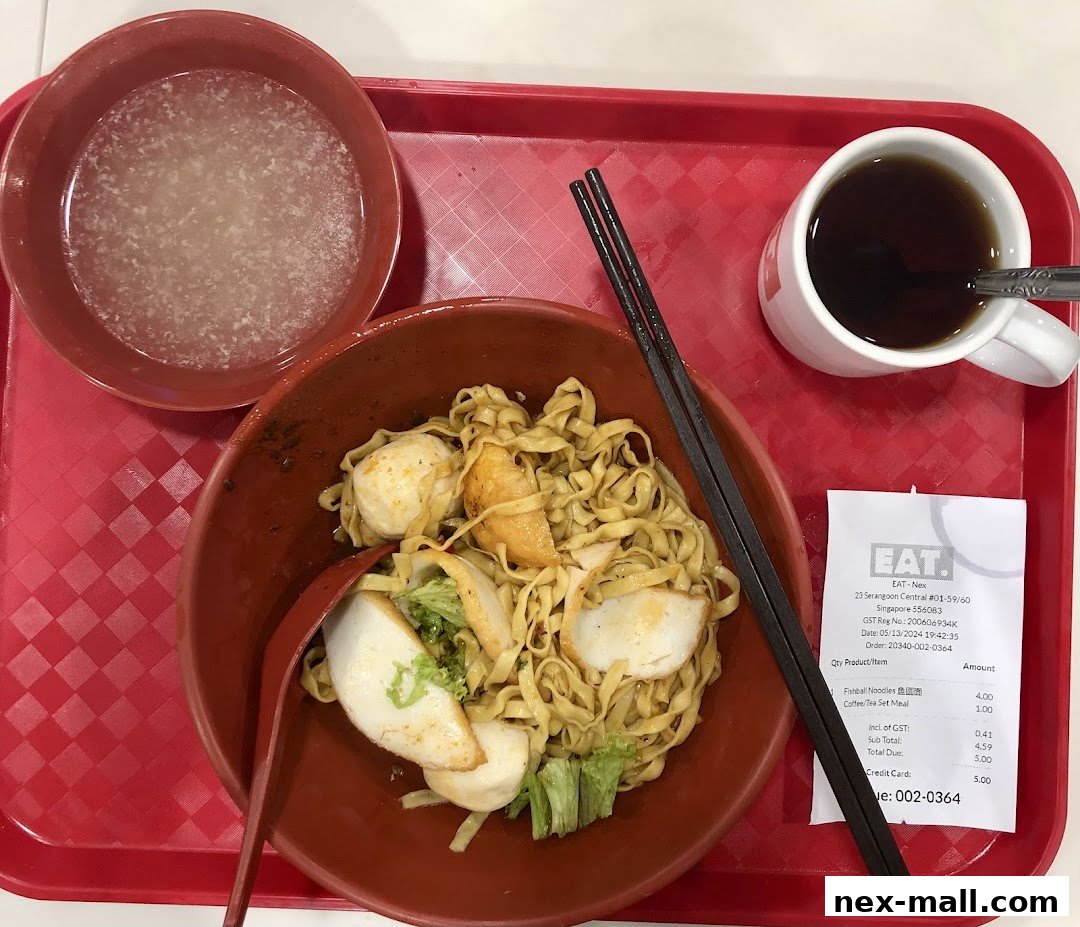 A bowl of fishball noodles with a side of soup and a cup of coffee on a red tray.
