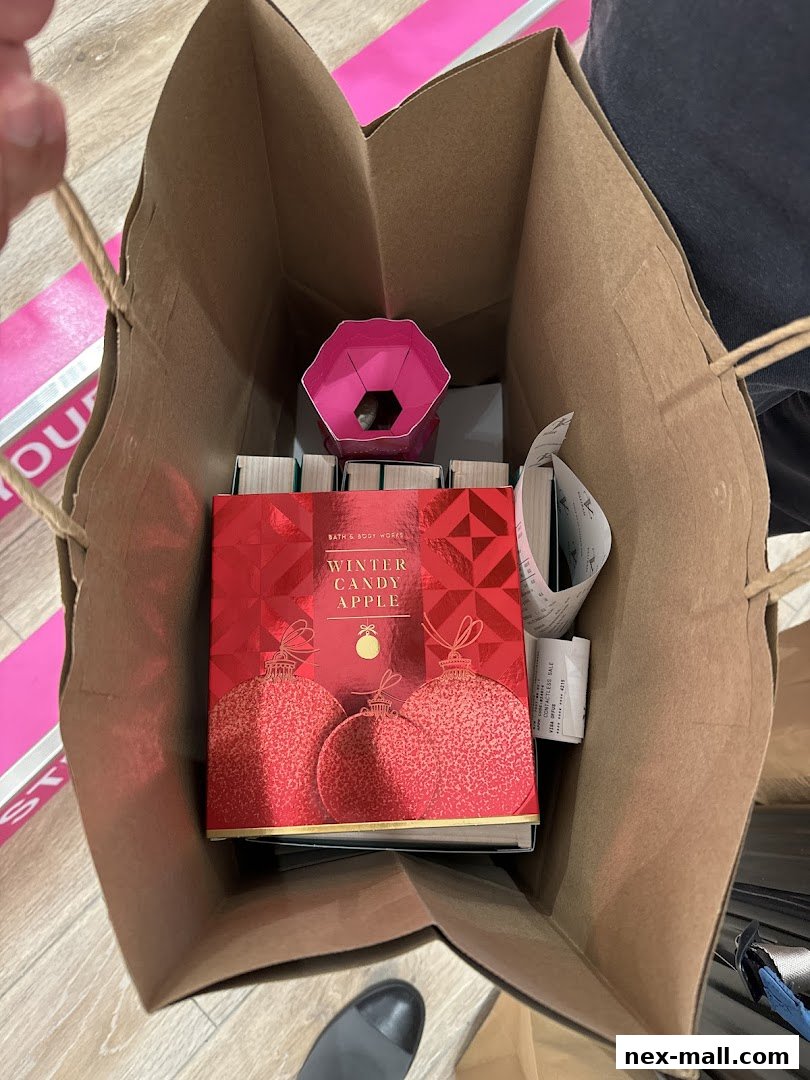 A shopping bag filled with Bath & Body Works products, including a Winter Candy Apple item.