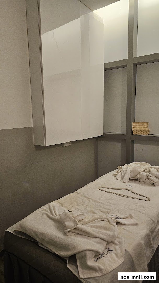 A treatment bed with towels and a hanger in a spa room.