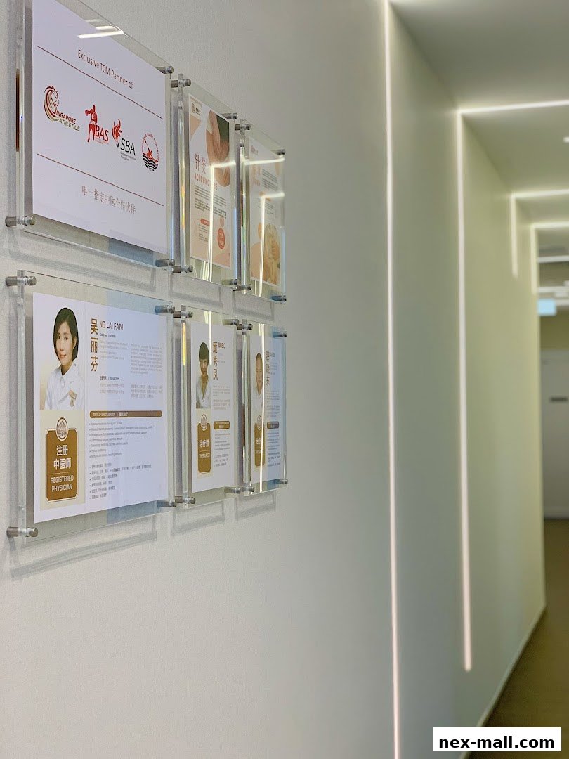 Certificates and information displayed on a wall in a modern clinic hallway.
