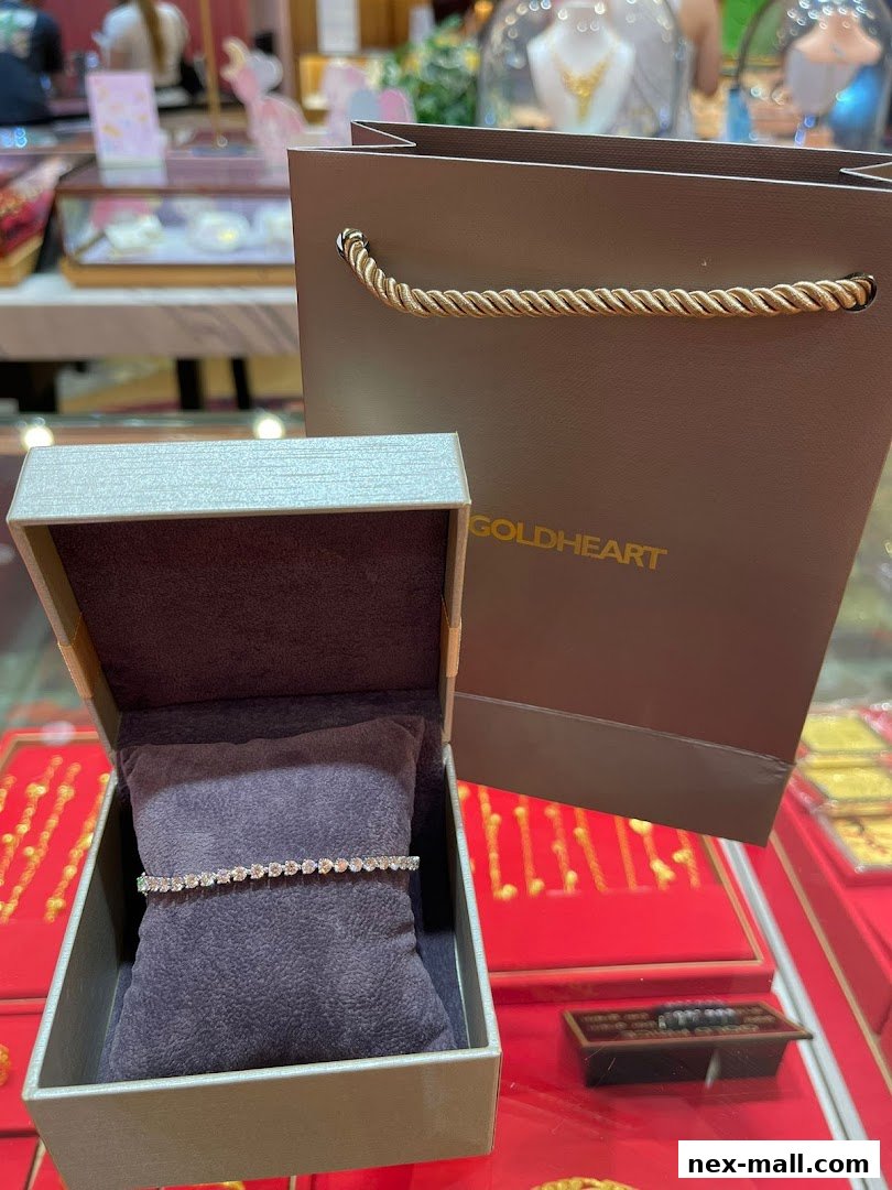 A diamond bracelet displayed in an open box next to a Goldheart shopping bag.