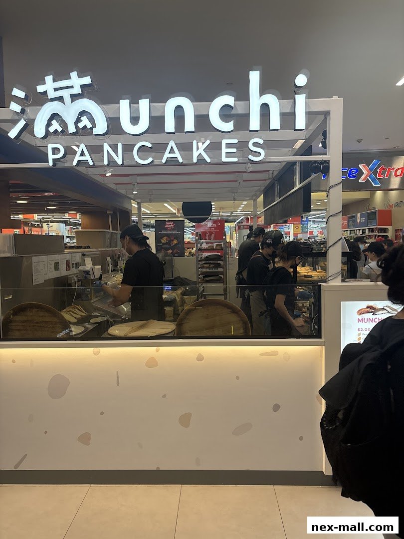 The Munchi Pancakes shop front with staff preparing food behind the counter.