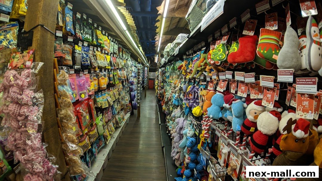 A wide aisle in a pet store filled with shelves of pet toys and treats.