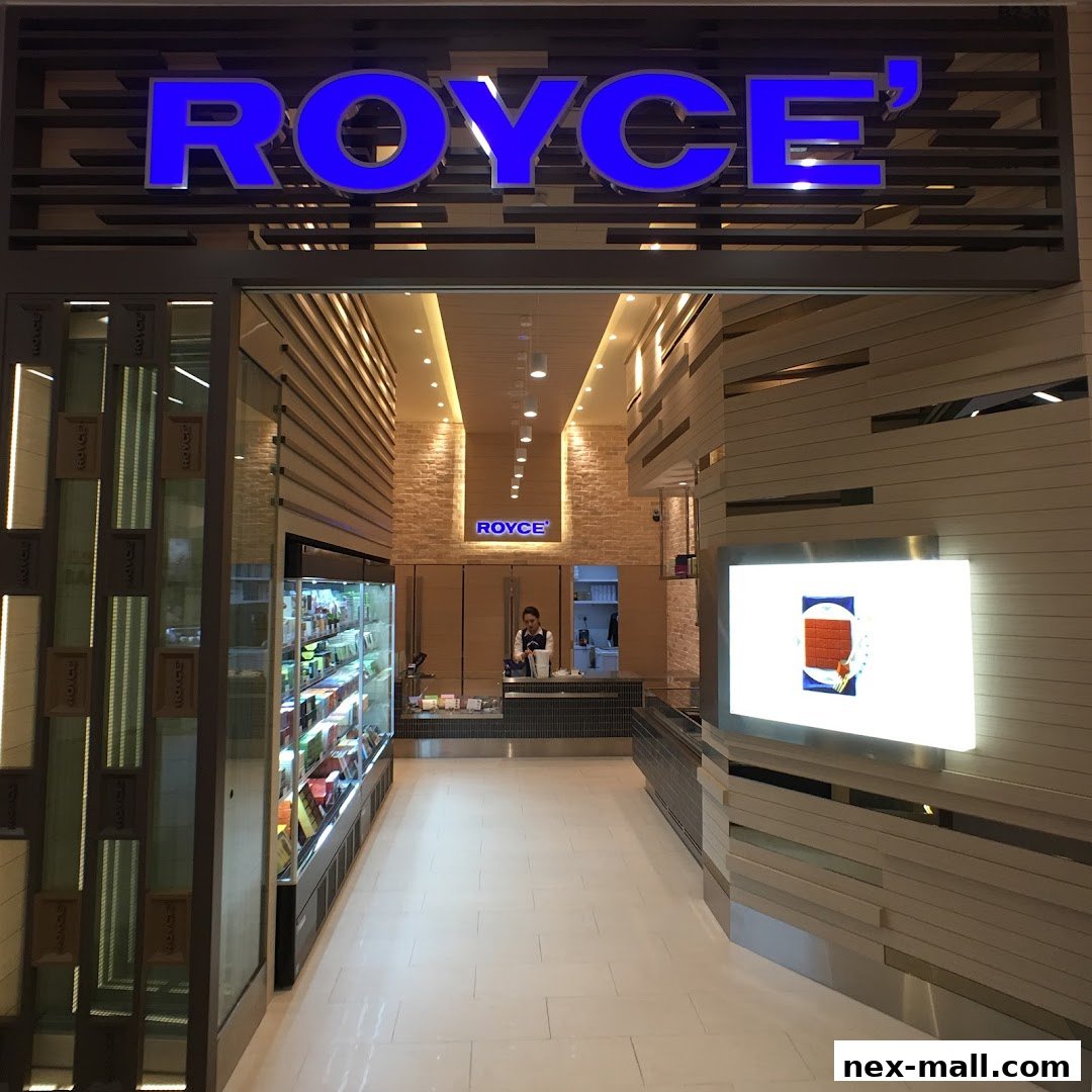 The entrance to a modern Royce shop with illuminated signage and a display of products.