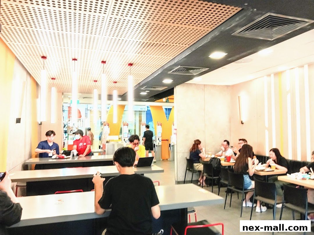 Interior view of a busy McDonald's restaurant with customers dining and staff working.