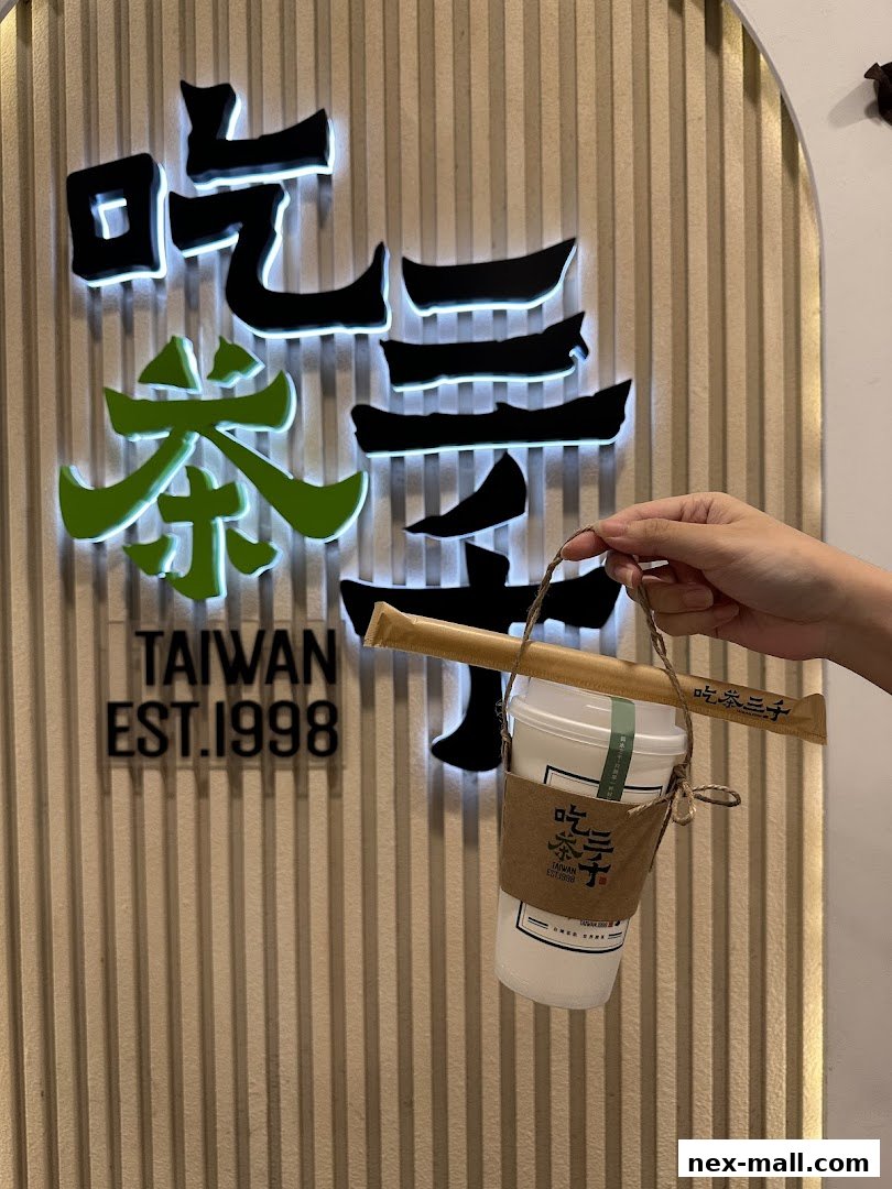 A hand holds a takeaway drink from CHICHA San Chen with the shop's logo in the background.