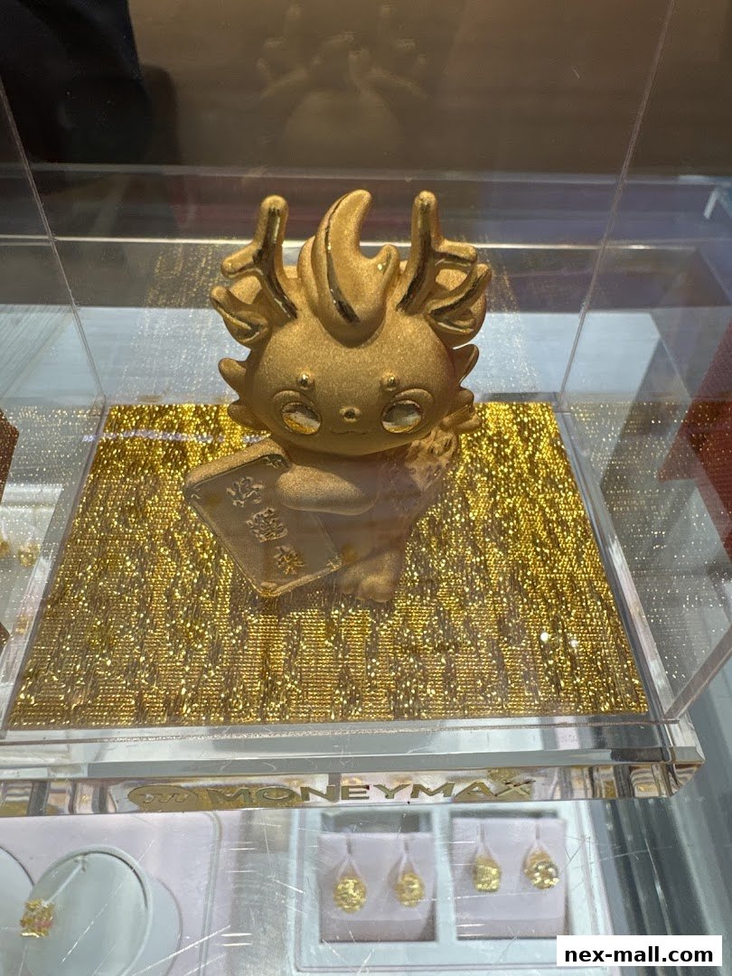 A golden figurine with antlers sits on a sparkling gold surface in a display case.