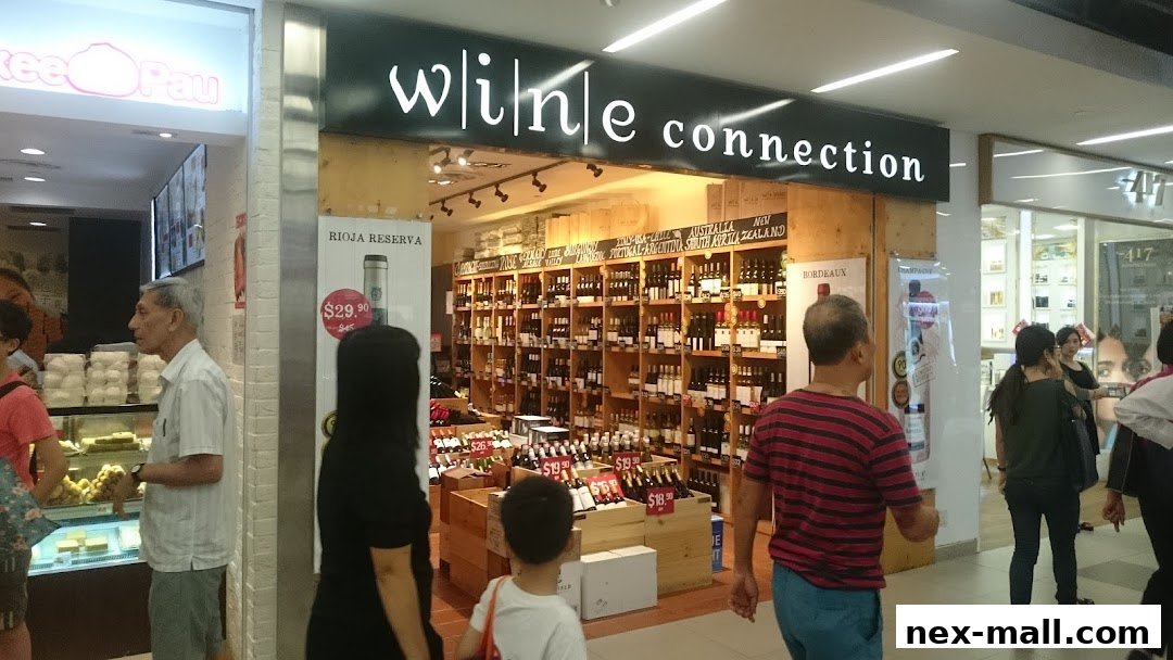 The exterior of a Wine Connection store, showcasing a wide selection of wines on shelves and in crates.