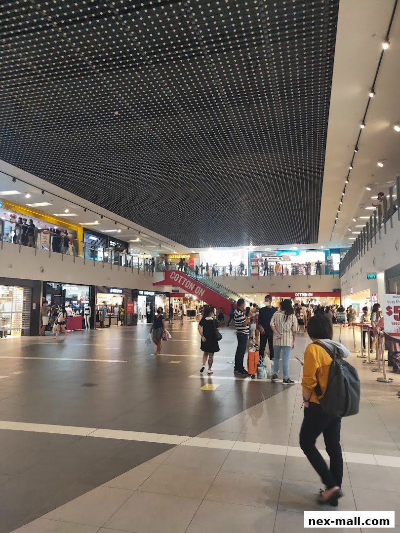 People walking in a mall with Cotton On store visible in the background.