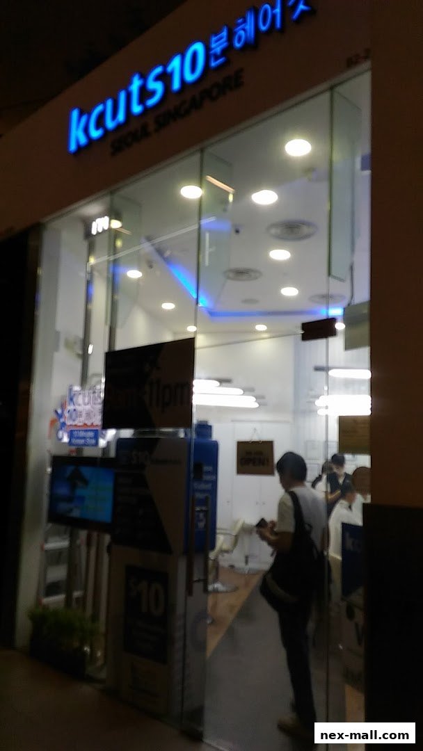 The brightly lit storefront of Kcuts hair salon, showcasing its modern interior and signage.