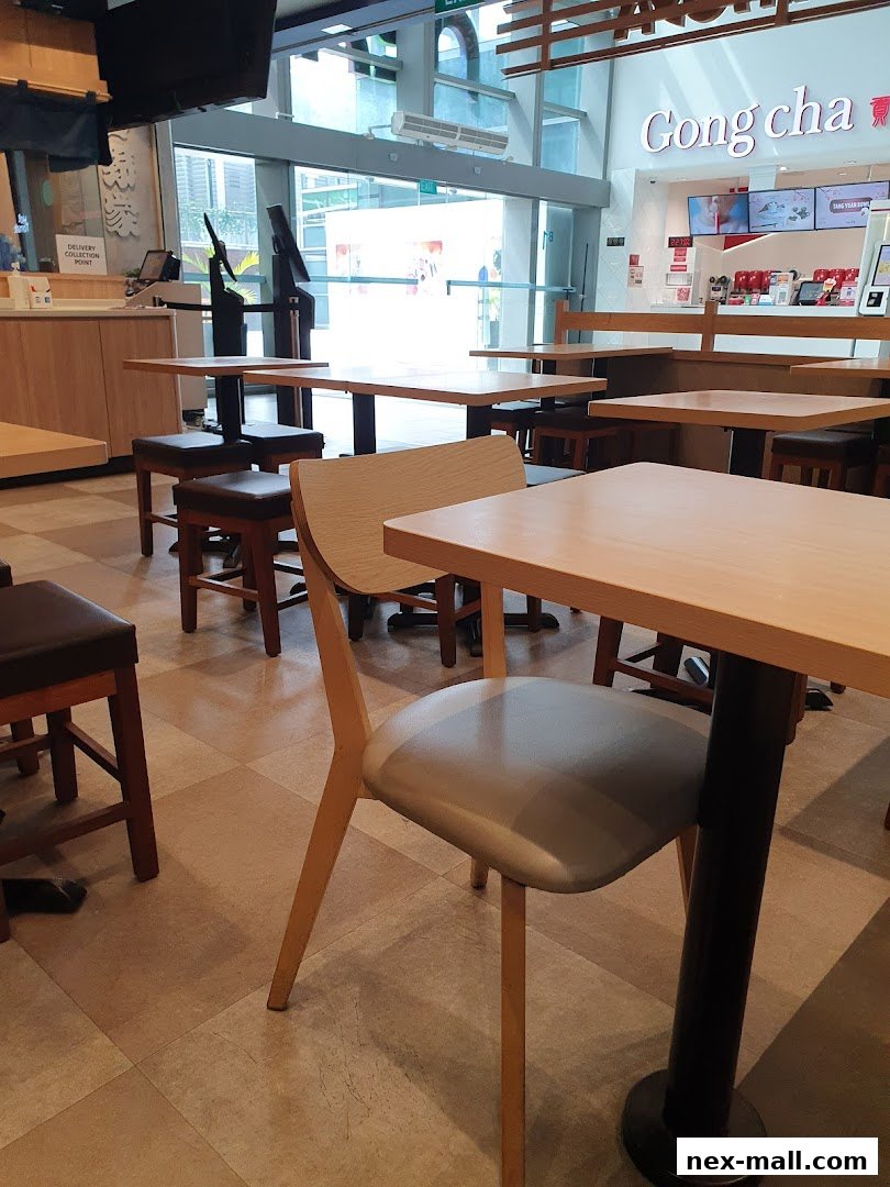 Interior view of a Gong Cha bubble tea shop with tables and chairs.