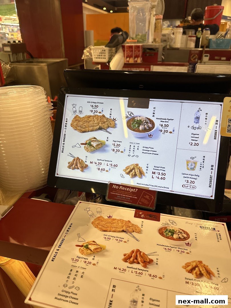 A digital menu board and a physical menu displaying Taiwanese street food items and prices.