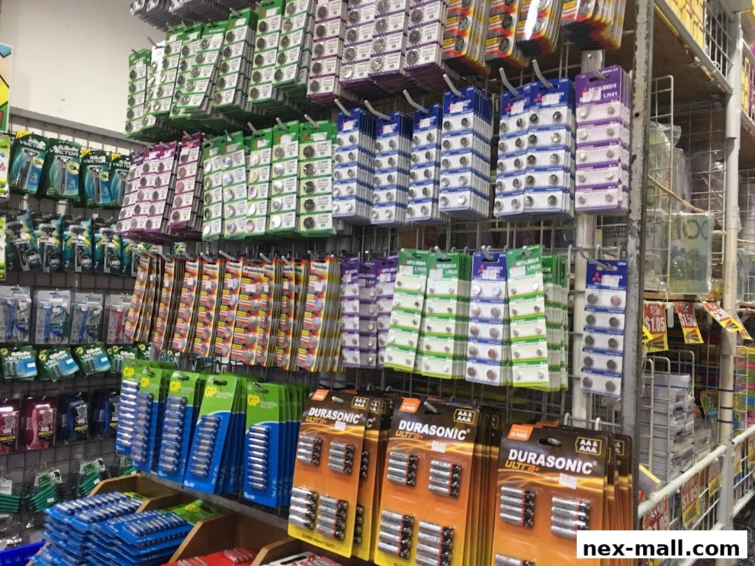 A wide selection of batteries and small electronic components are neatly displayed on shelves.