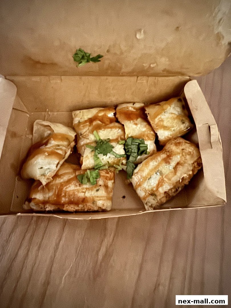 A close-up shot of Taiwanese fried snacks in a takeout box, garnished with cilantro.