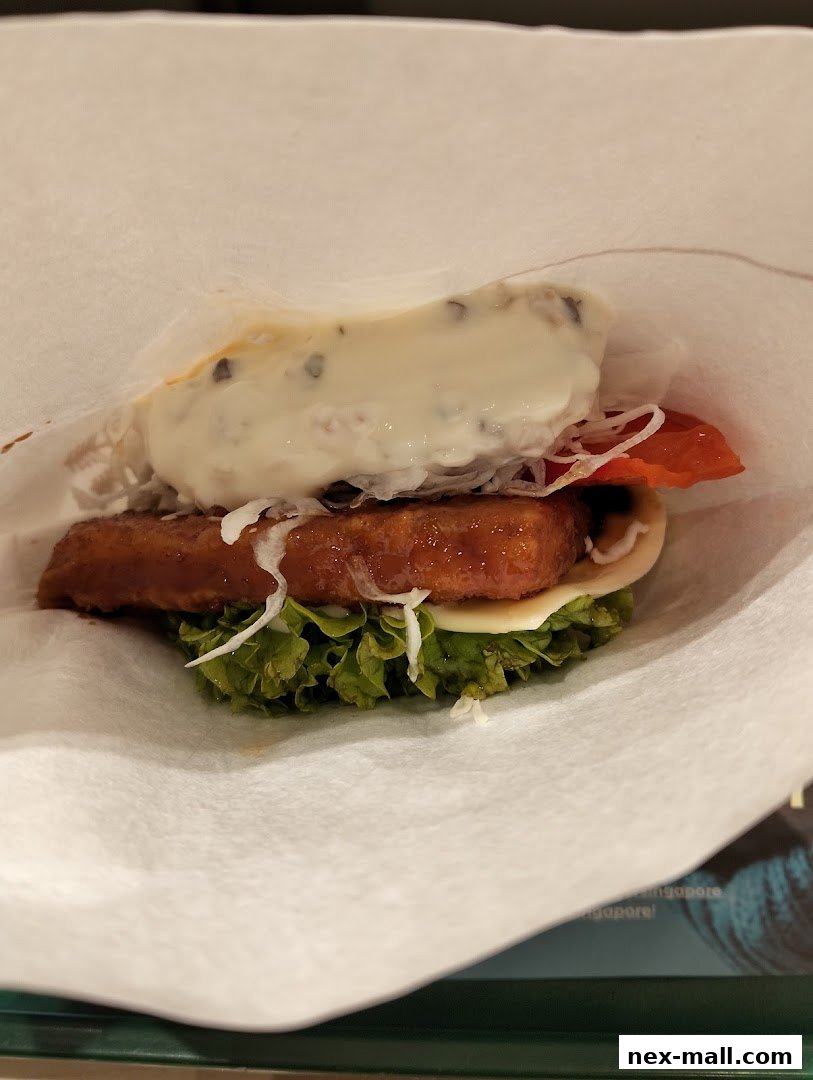 A close-up shot of a delicious MOS Burger with fresh lettuce, cheese, and a generous topping.