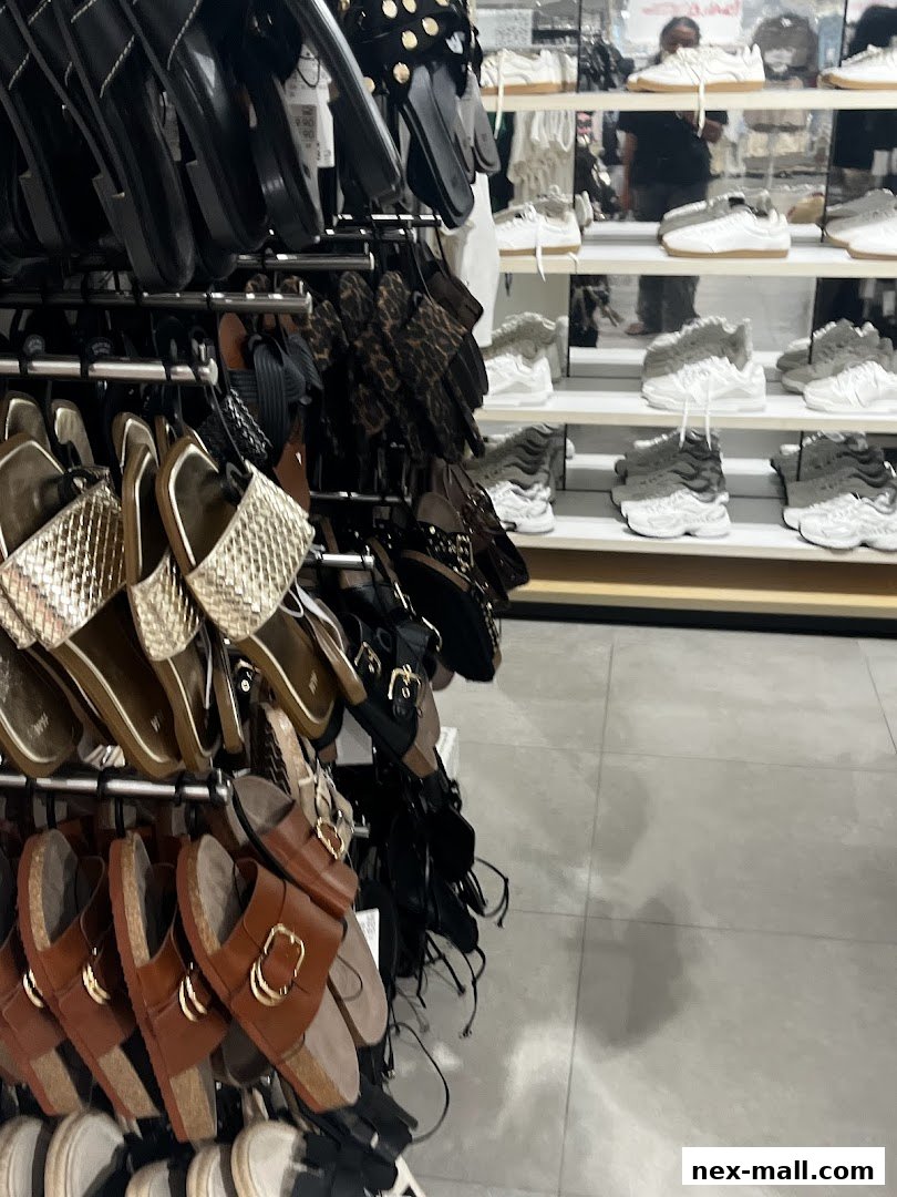 A display of various sandals and sneakers on racks inside a retail store.