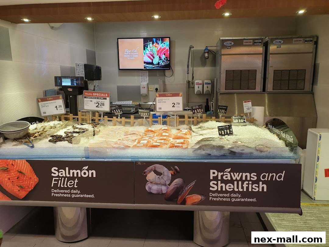 A display of fresh seafood including salmon fillets, prawns, shellfish, and assorted fish fillets on ice.