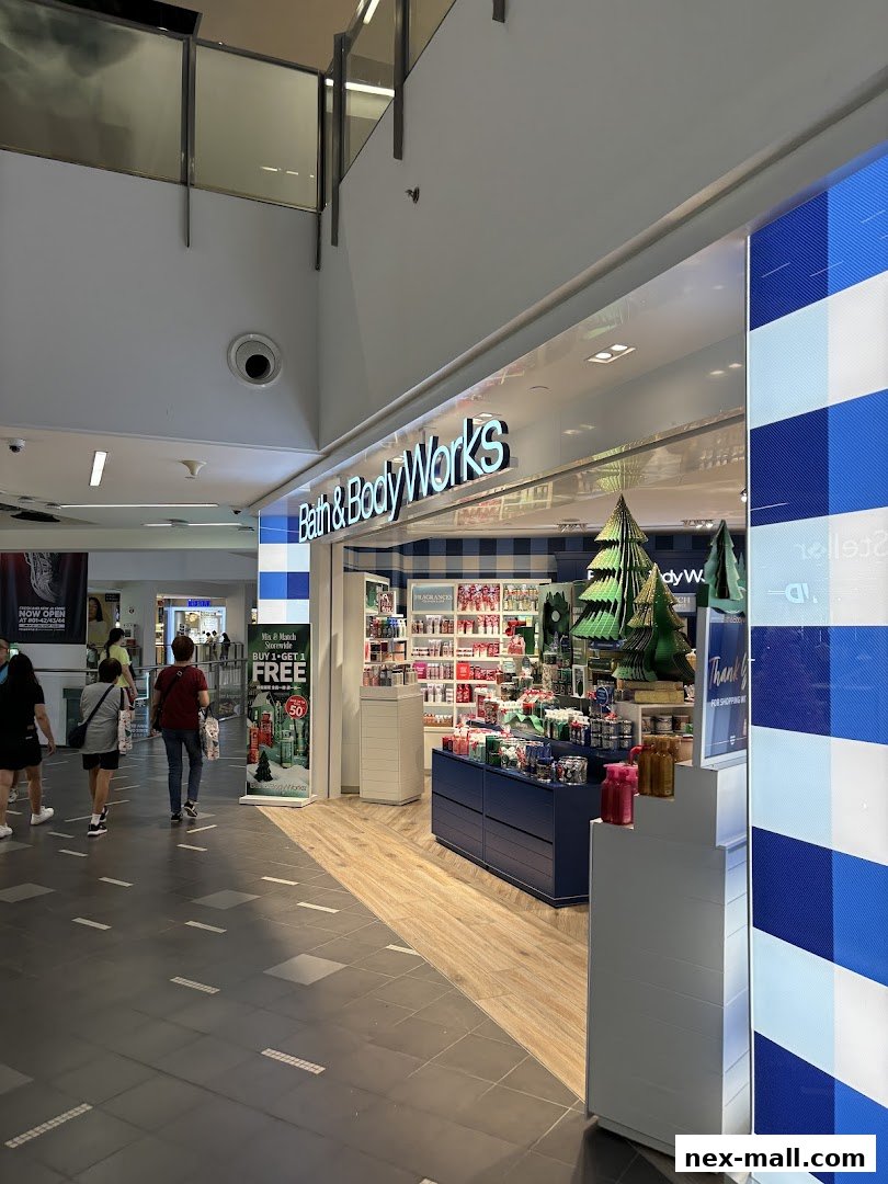 The exterior of a Bath & Body Works store with products displayed inside and a promotional banner.