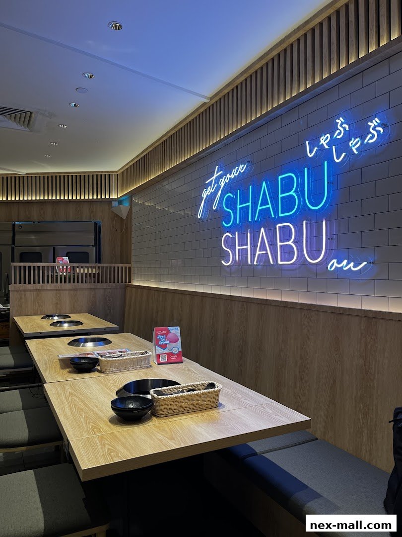Interior of a Japanese Shabu-Shabu restaurant with neon signs and dining tables.