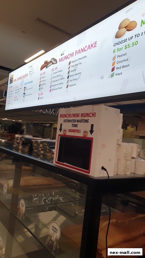 A brightly lit menu board displaying various pancake flavors and fillings at Munchi Pancakes.