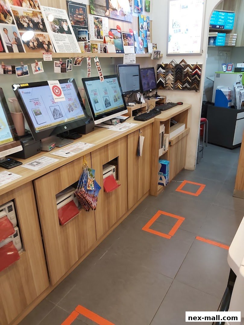 Interior of a photo printing and framing shop with computers and displays.