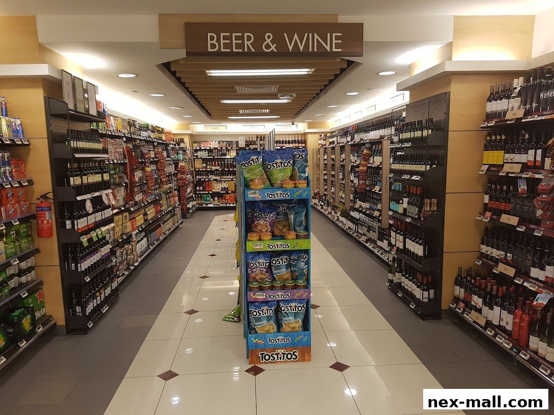 Aisle in a supermarket with shelves stocked with beer, wine, and snacks.