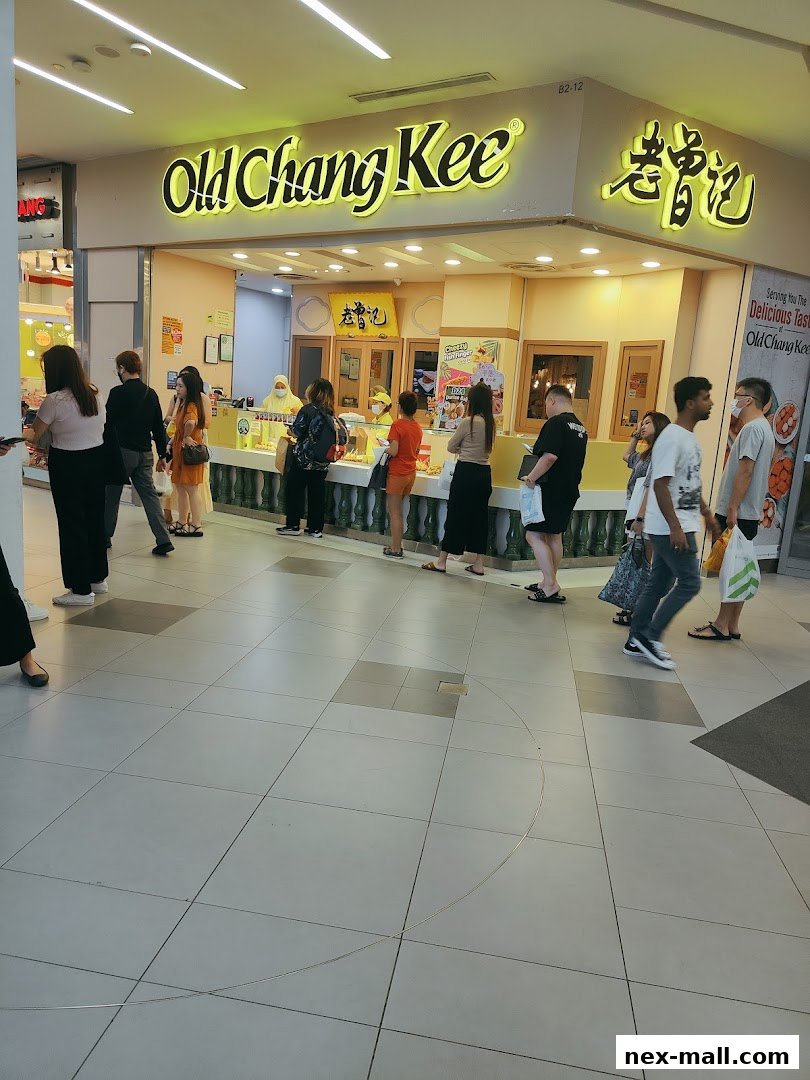 People queuing at the Old Chang Kee shop entrance, with its prominent signage.