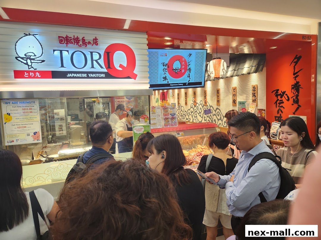 A busy TORI-Q Japanese Yakitori shop with customers queuing and staff preparing food.