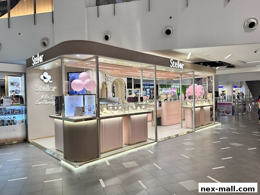 A modern, pink-themed ear piercing and jewelry shop with display cases and signage.