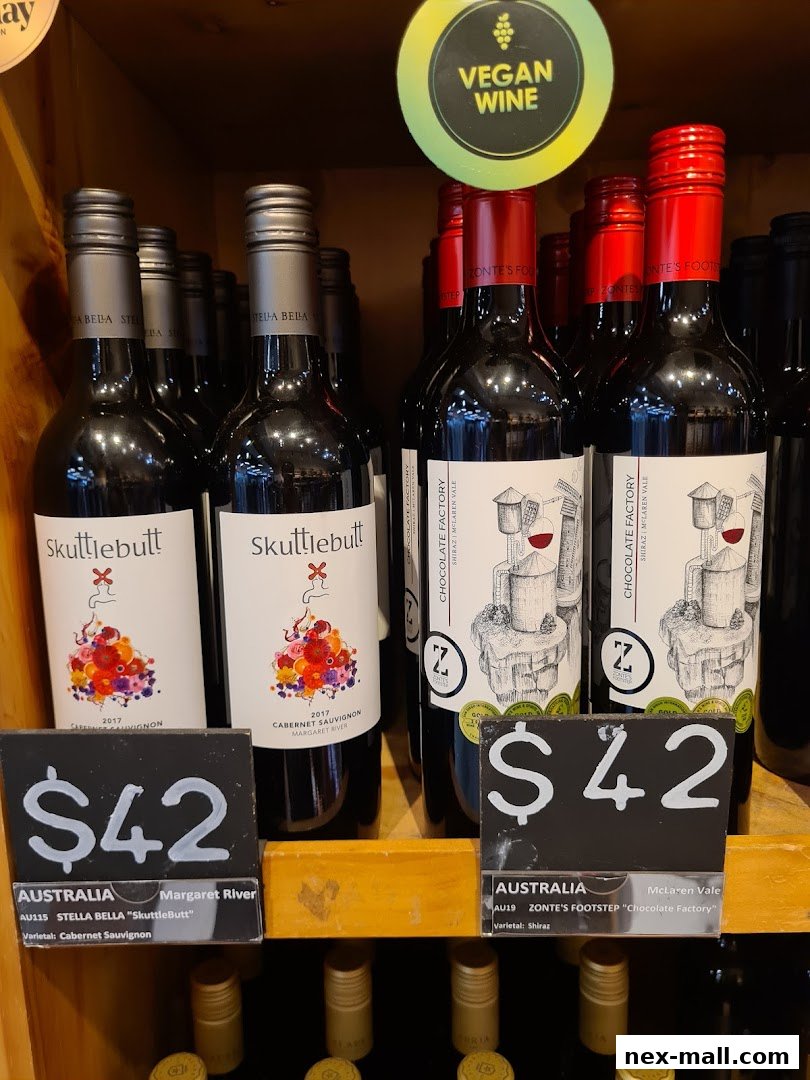 Bottles of wine with price tags and a 'Vegan Wine' sign are displayed on shelves.