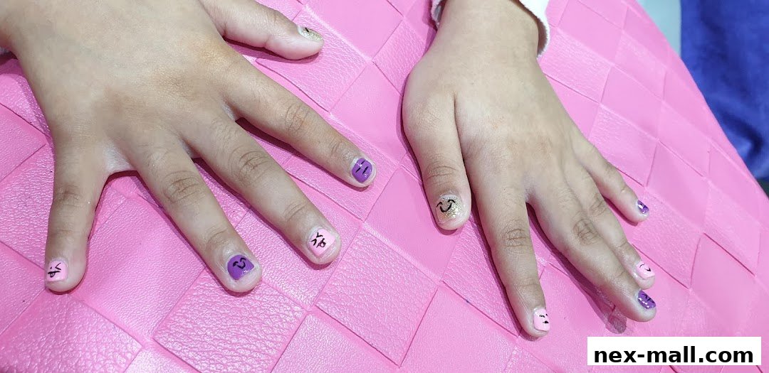 Close-up of hands with colorful, creatively designed nails featuring smiley faces and patterns.