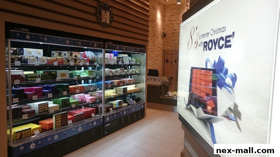 A well-lit shop interior showcasing a wide selection of Royce chocolates in refrigerated display cases.