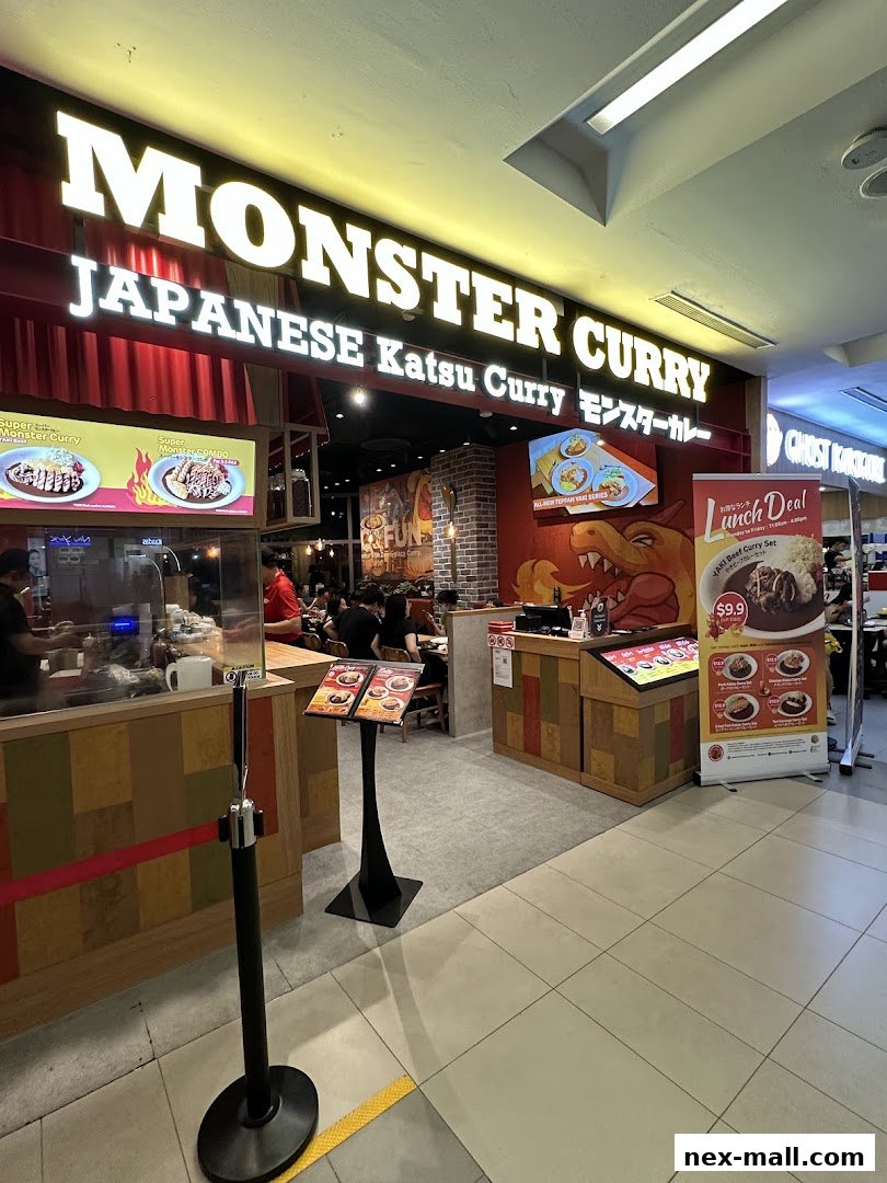 The exterior of Monster Curry, a Japanese Katsu Curry restaurant, with its prominent signage and a lunch deal poster.