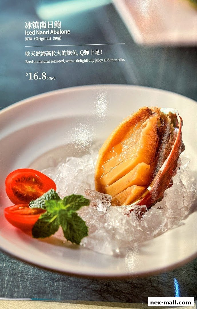 A close-up of Iced Nanri Abalone served on ice with cherry tomatoes and mint.