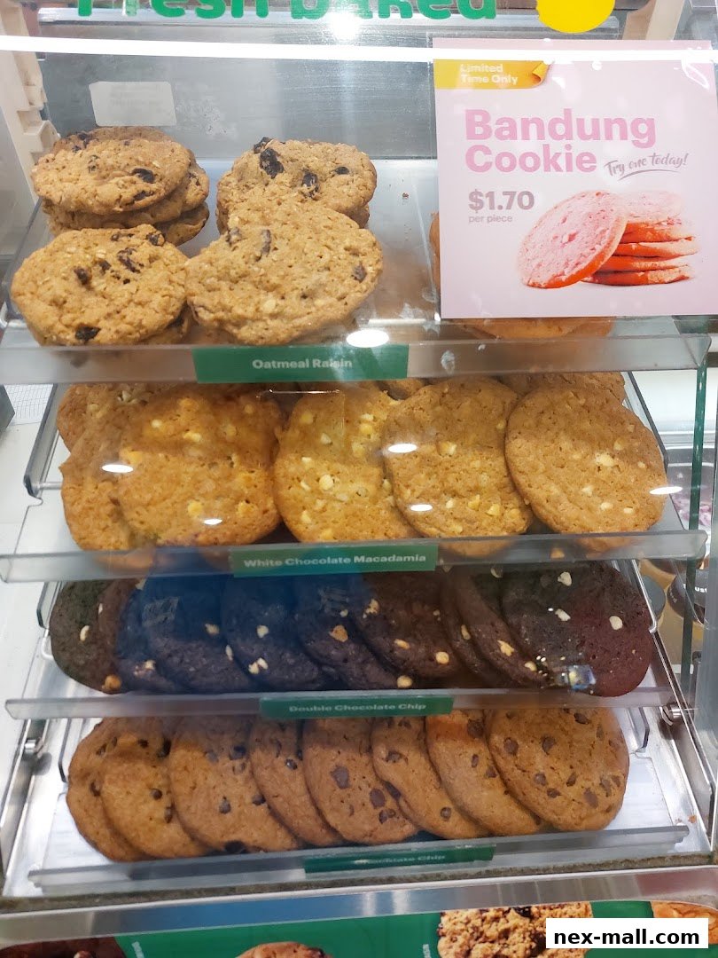 A display case filled with various types of freshly baked cookies at Subway.