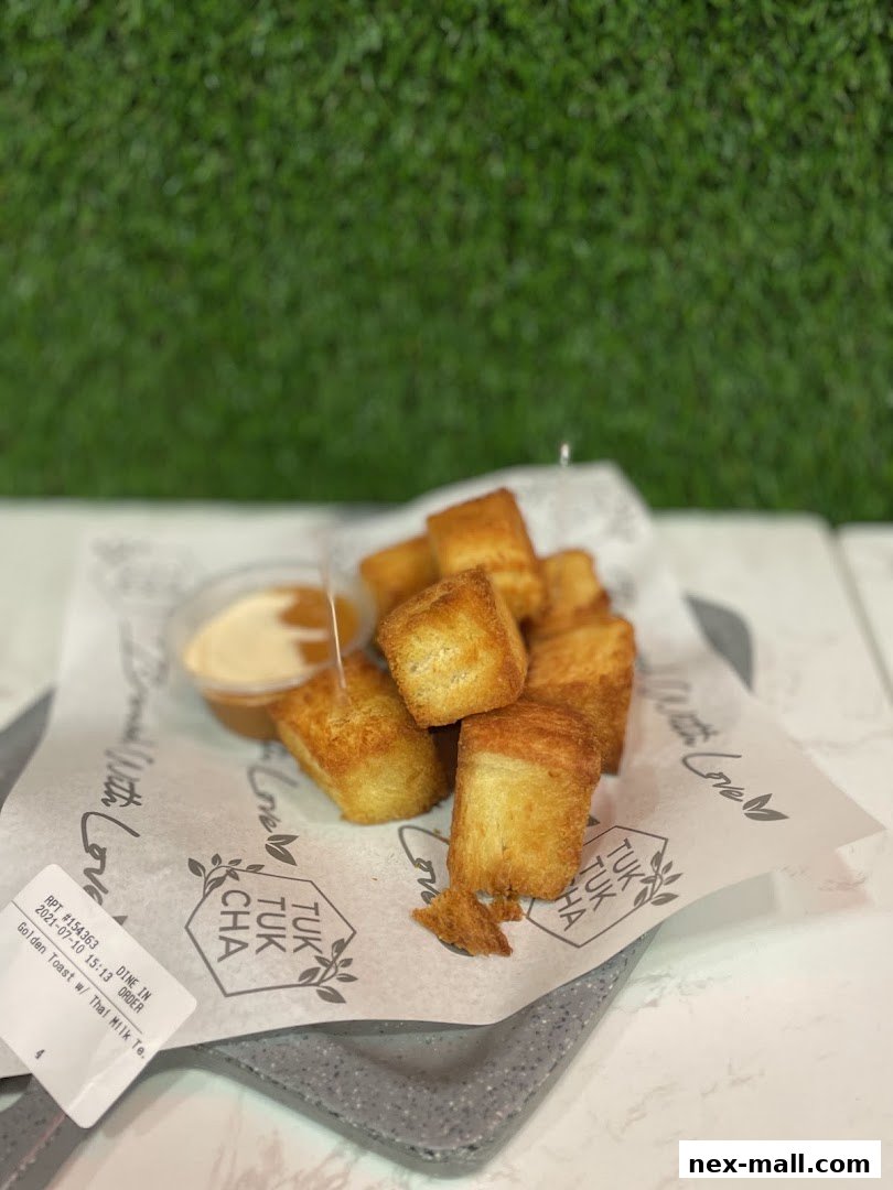 Golden toast cubes served with a dipping sauce on branded paper.