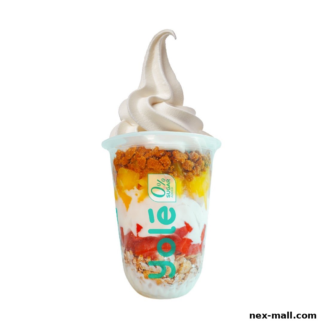 A layered frozen yogurt dessert with fruit, granola, and a swirl of soft serve.