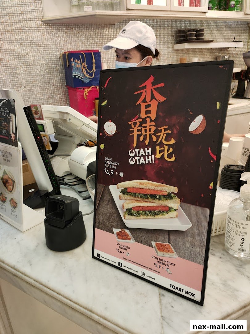 A sign displays Toast Box's Otah sandwich and other otah products with prices.