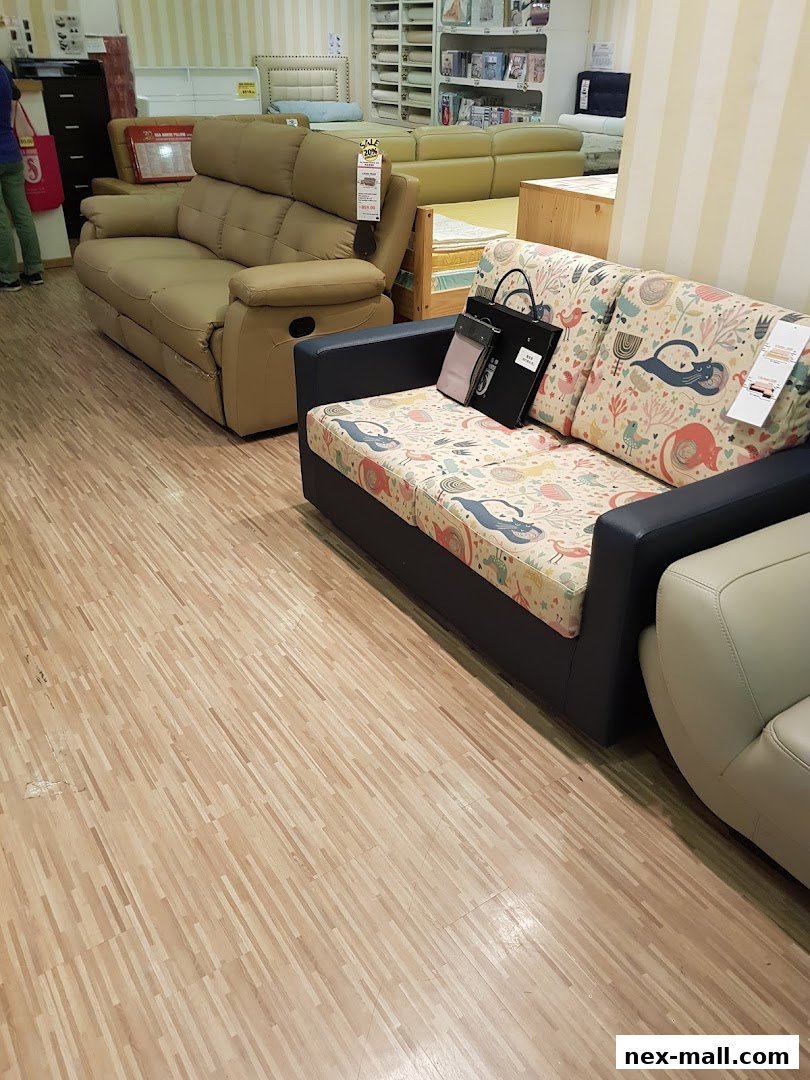 A furniture store interior showcasing various sofas and beds with decorative pillows.