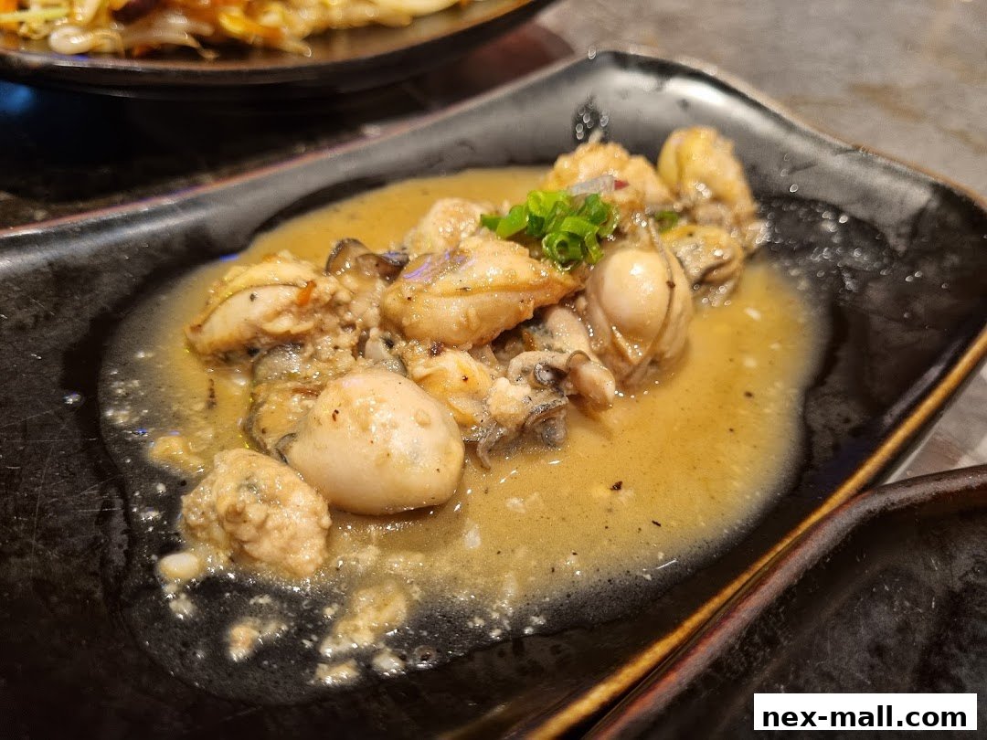 A close-up of oysters in a savory sauce, garnished with green onions.