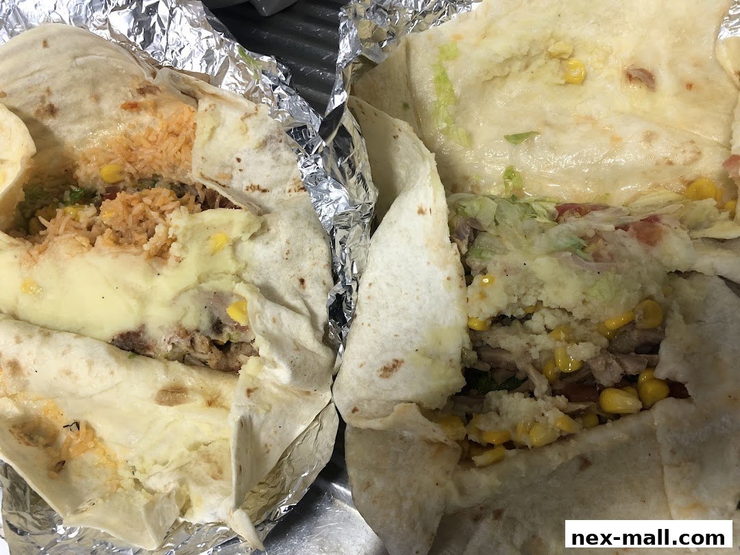 Two delicious burritos filled with rice, corn, meat, and cheese, wrapped in foil.