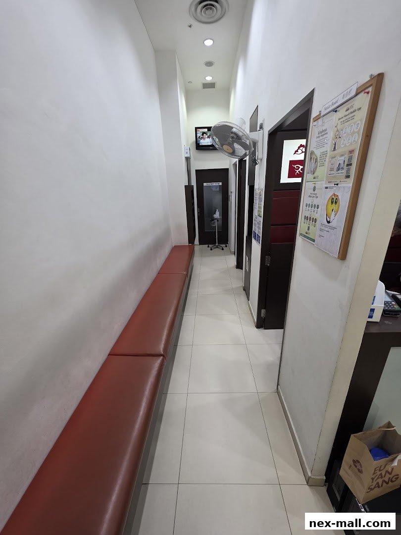 Interior hallway of a clinic with a waiting bench and doors to treatment rooms.