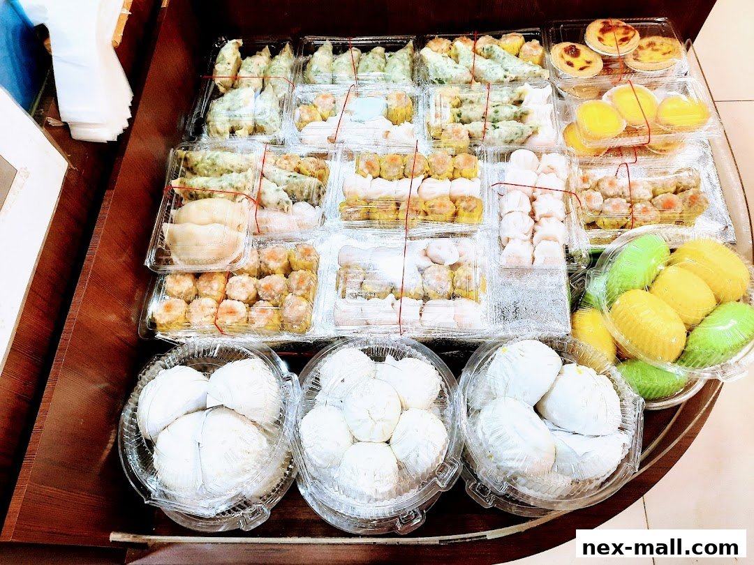 A variety of dim sum and pastries are neatly arranged in clear plastic containers.