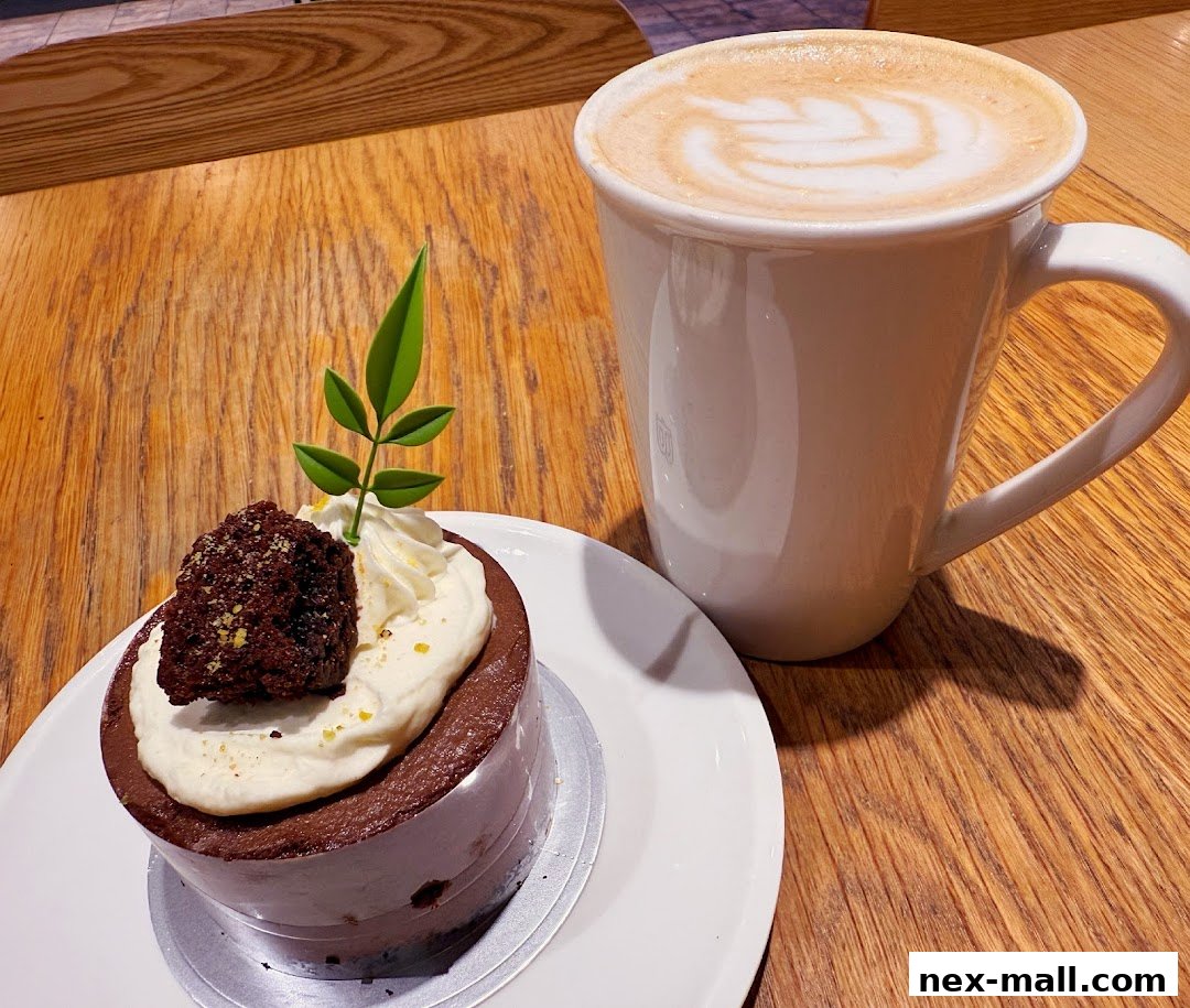 A delicious chocolate cake with cream and a latte art coffee on a wooden table.