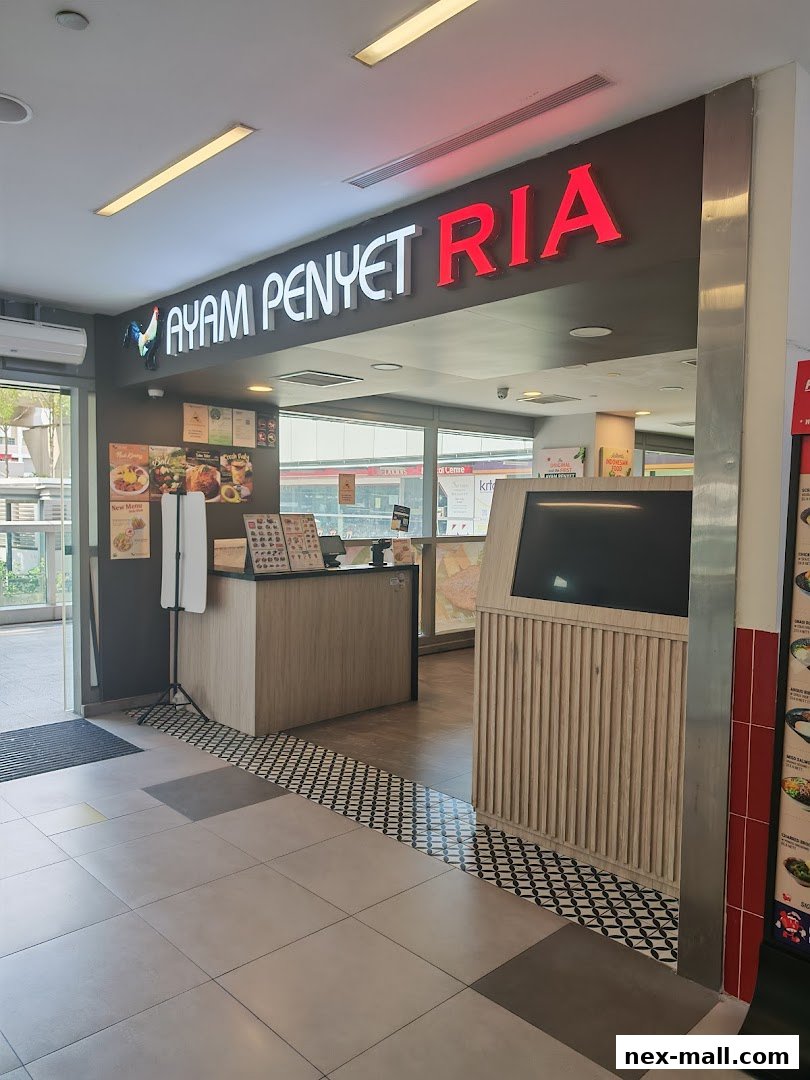 The entrance of Ayam Penyet Ria, a restaurant with a prominent sign and a counter.